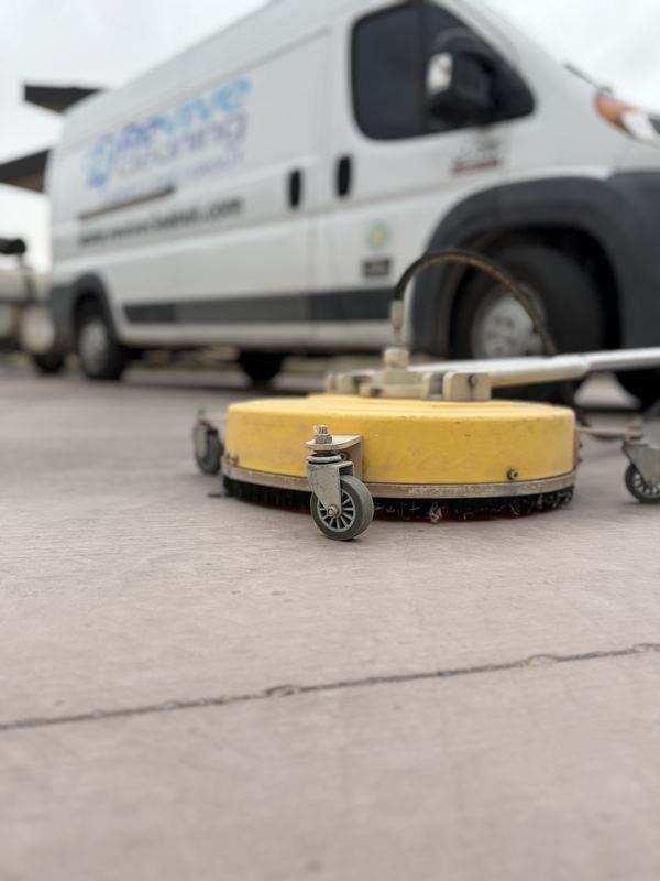 Revive Cleaning's surface cleaner attachment and branded service van on a job site